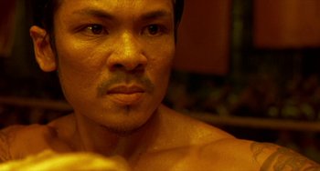 Movie still from “Ong-Bak: The Thai Warrior” (2003), directed by Prachya Pinkaew – A man's face in a room; Close Up shot, Low angle