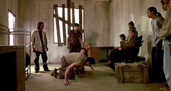 Movie still from “Ong-Bak: The Thai Warrior” (2003), directed by Prachya Pinkaew – A group of people standing in a room; Wide shot, High angle
