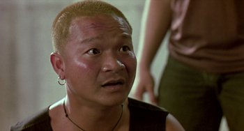 Movie still from “Ong-Bak: The Thai Warrior” (2003), directed by Prachya Pinkaew – A man with a shaved head looking at the camera; Close Up shot, High angle