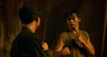 Movie still from “Ong-Bak: The Thai Warrior” (2003), directed by Prachya Pinkaew – Two men are fighting each other in a dark room; Medium shot, Over the shoulder angle
