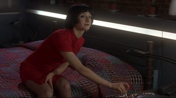 Movie still from “Open Your Eyes” (1997), directed by Alejandro Amenábar – A woman sitting on top of a bed wearing a red dress; Medium shot, High angle