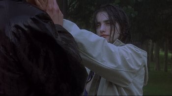 Movie still from “Open Your Eyes” (1997), directed by Alejandro Amenábar – A young woman in a raincoat holding onto a horse; Close Up shot, Over the shoulder angle