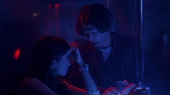 Movie still from “Open Your Eyes” (1997), directed by Alejandro Amenábar – A man and a woman looking at a cell phone in a dark room; Medium shot, Over the shoulder angle