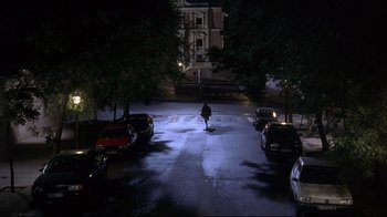 Movie still from “Open Your Eyes” (1997), directed by Alejandro Amenábar – A person walking down a street at night; Extreme Wide shot, High angle
