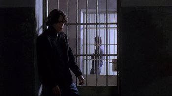 Movie still from “Open Your Eyes” (1997), directed by Alejandro Amenábar – A man standing next to a jail cell; Medium shot, Low angle
