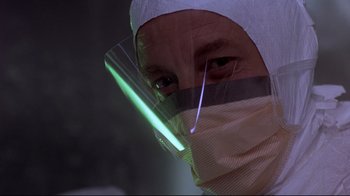Movie still from “Open Your Eyes” (1997), directed by Alejandro Amenábar – A man wearing a face mask and a face shield; Close Up shot, Low angle