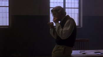 Movie still from “Open Your Eyes” (1997), directed by Alejandro Amenábar – A man standing in front of a window in a dark room; Medium shot, Over the shoulder angle