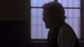 Movie still from “Open Your Eyes” (1997), directed by Alejandro Amenábar – A man with a beard and glasses is looking out the window; Close Up shot, Over the shoulder angle