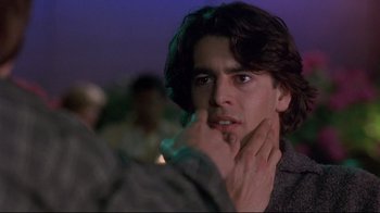 Movie still from “Open Your Eyes” (1997), directed by Alejandro Amenábar – A young man with long dark hair looking at the camera; Close Up shot, Over the shoulder angle