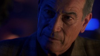 Movie still from “Open Your Eyes” (1997), directed by Alejandro Amenábar – An old man with a blue face and a wrinkled face; Close Up shot, Over the shoulder angle