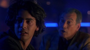 Movie still from “Open Your Eyes” (1997), directed by Alejandro Amenábar – Two men in a dark room one of which is looking at the camera and the other is looking at the camera; Close Up shot, Over the shoulder angle
