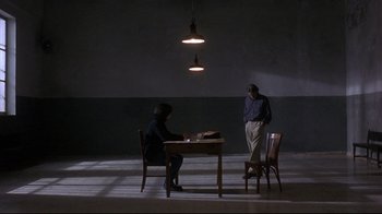 Movie still from “Open Your Eyes” (1997), directed by Alejandro Amenábar – Two people sitting at a table in a dimly - lit room; Wide shot, Over the shoulder angle
