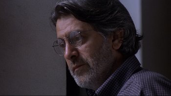 Movie still from “Open Your Eyes” (1997), directed by Alejandro Amenábar – A person wearing glasses and a plaid shirt; Close Up shot, Low angle