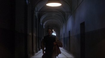 Movie still from “Open Your Eyes” (1997), directed by Alejandro Amenábar – A man walking down a hallway in a building; Wide shot, Low angle