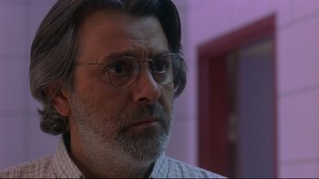 Movie still from “Open Your Eyes” (1997), directed by Alejandro Amenábar – A man with a beard wearing glasses looking at the camera; Close Up shot, Over the shoulder angle
