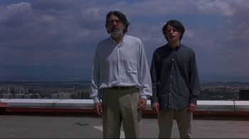 Movie still from “Open Your Eyes” (1997), directed by Alejandro Amenábar – Two men standing on a roof top in front of a city skyline; Medium shot, Low angle
