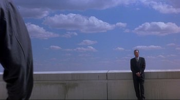 Movie still from “Open Your Eyes” (1997), directed by Alejandro Amenábar – A man in a suit standing on the side of a building; Wide shot, Low angle