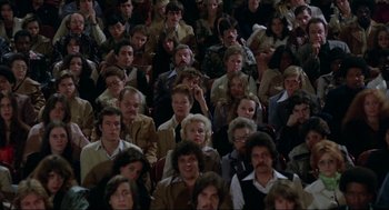 Movie still from “Opening Night” (1977), directed by John Cassavetes – A large group of people sitting in a room together; Wide shot, High angle