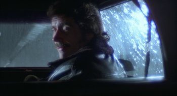 Movie still from “Opening Night” (1977), directed by John Cassavetes – A man in a leather jacket sitting in the back of a car; Close Up shot, Over the shoulder angle