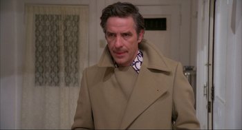 Movie still from “Opening Night” (1977), directed by John Cassavetes – A man in a tan coat standing next to a wall; Close Up shot, Low angle