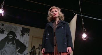 Movie still from “Opening Night” (1977), directed by John Cassavetes – A woman wearing a jacket and a brown skirt; Medium shot, Low angle