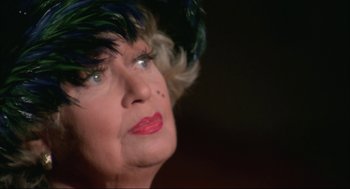Movie still from “Opening Night” (1977), directed by John Cassavetes – An older woman wearing a hat with feathers on top of her head; Close Up shot, Low angle