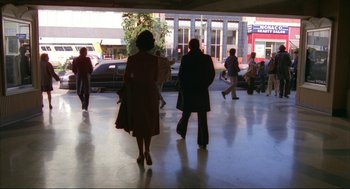Movie still from “Opening Night” (1977), directed by John Cassavetes – A group of people walking on a sidewalk near a building; Wide shot, Low angle