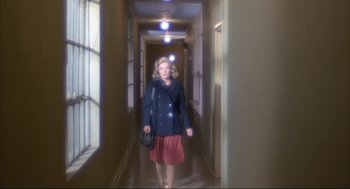 Movie still from “Opening Night” (1977), directed by John Cassavetes – A woman walking down a long hallway in a building; Wide shot, Low angle