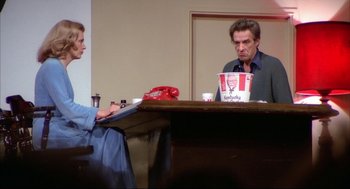 Movie still from “Opening Night” (1977), directed by John Cassavetes – Two people sitting at a table with a cup of coffee; Wide shot, Low angle