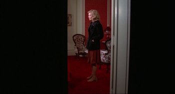 Movie still from “Opening Night” (1977), directed by John Cassavetes – A woman standing in front of a mirror in a room; Wide shot, High angle