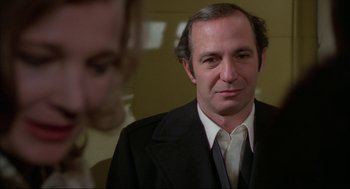 Movie still from “Opening Night” (1977), directed by John Cassavetes – A person wearing a suit and tie; Close Up shot, Over the shoulder angle