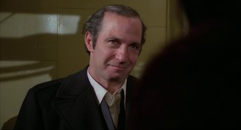 Movie still from “Opening Night” (1977), directed by John Cassavetes – A person wearing a suit and tie; Close Up shot, Over the shoulder angle