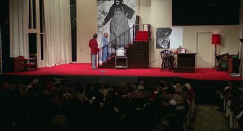 Movie still from “Opening Night” (1977), directed by John Cassavetes – Two people standing on a stage in front of an audience; Wide shot, High angle