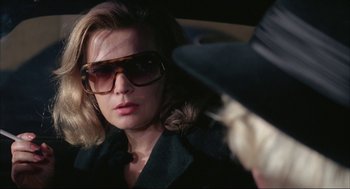 Movie still from “Opening Night” (1977), directed by John Cassavetes – A person wearing sunglasses and a hat; Close Up shot, Over the shoulder angle