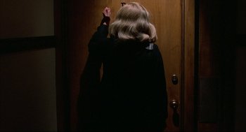 Movie still from “Opening Night” (1977), directed by John Cassavetes – A woman standing in front of a wooden door; Close Up shot, Over the shoulder angle