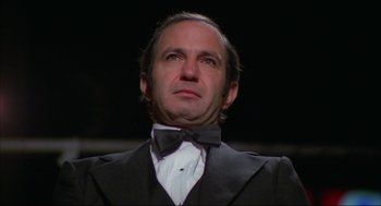 Movie still from “Opening Night” (1977), directed by John Cassavetes – A person wearing a suit and bow tie; Close Up shot, Low angle