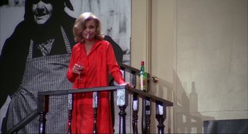 Movie still from “Opening Night” (1977), directed by John Cassavetes – A woman in a red outfit smoking a cigarette; Medium shot, Low angle