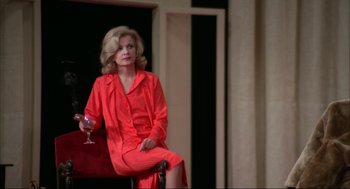 Movie still from “Opening Night” (1977), directed by John Cassavetes – A woman sitting on a chair holding a glass of wine; Medium shot, High angle