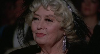 Movie still from “Opening Night” (1977), directed by John Cassavetes – An older woman wearing a black dress and a black hat; Close Up shot, Over the shoulder angle