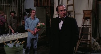 Movie still from “Opening Night” (1977), directed by John Cassavetes – A man in a tuxedo holding a bunch of flowers; Medium shot, Over the shoulder angle