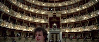 Movie still from “Opera” (1987), directed by Dario Argento – A man standing in front of an ornate theater; Wide shot, Low angle