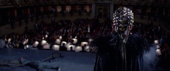 Movie still from “Opera” (1987), directed by Dario Argento – A woman in a black dress with feathers on her head; Close Up shot, Over the shoulder angle