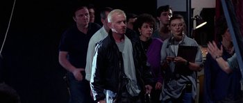 Movie still from “Opera” (1987), directed by Dario Argento – A group of people standing in front of a wall; Medium shot, High angle