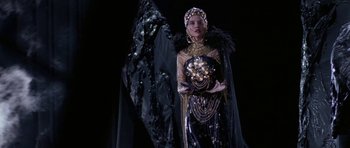 Movie still from “Opera” (1987), directed by Dario Argento – A woman in a black and gold outfit and a black veil; Medium shot, Low angle