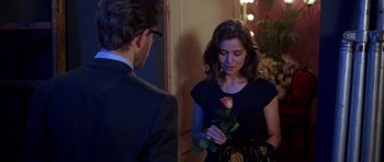 Movie still from “Opera” (1987), directed by Dario Argento – A woman holding a rose in front of a man; Medium shot, Over the shoulder angle