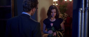 Movie still from “Opera” (1987), directed by Dario Argento – A woman holding a rose in her hand and a man standing next to her; Medium shot, Over the shoulder angle