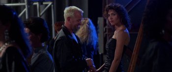 Movie still from “Opera” (1987), directed by Dario Argento – A man and a woman standing next to each other; Medium shot, Over the shoulder angle