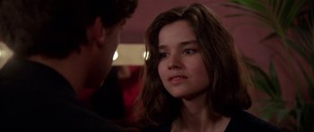 Movie still from “Opera” (1987), directed by Dario Argento – A young woman looking at the camera while a man looks at her; Close Up shot, Over the shoulder angle