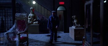 Movie still from “Opera” (1987), directed by Dario Argento – A man walking in the dark in front of some statues; Wide shot, High angle