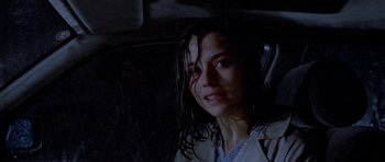 Movie still from “Opera” (1987), directed by Dario Argento – A woman with wet hair and a white shirt is smiling for the camera; Close Up shot, Over the shoulder angle